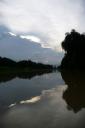 De zon achter de wolken terwijl je dobbert op de rivier